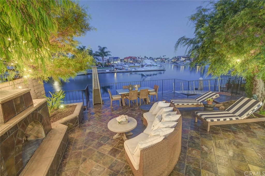 3901 Aruba Circle Huntington Beach, CA 92649 - Photo 47 of 56 a view of a patio with table and chairs potted plants with wooden floor and fence