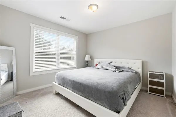a large bed sitting in a bedroom next to a window