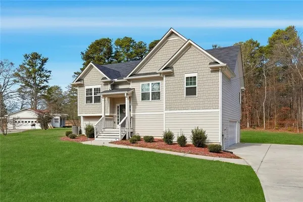 a front view of a house with a garden and yard