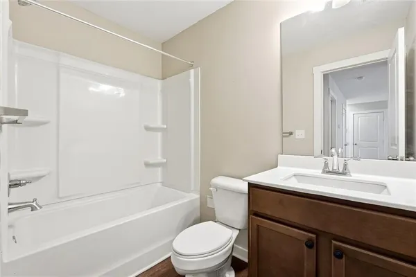 a bathroom with a sink a toilet a mirror and shower