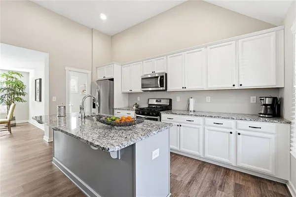 a kitchen with stainless steel appliances granite countertop a sink stove and refrigerator