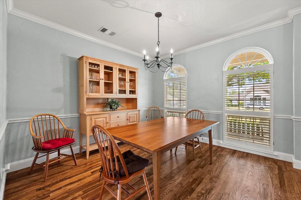 425 Chippendale Drive Heath, TX 75032 - Photo 13 of 37 a dining room with wooden floor a chandelier a wooden table and chairs