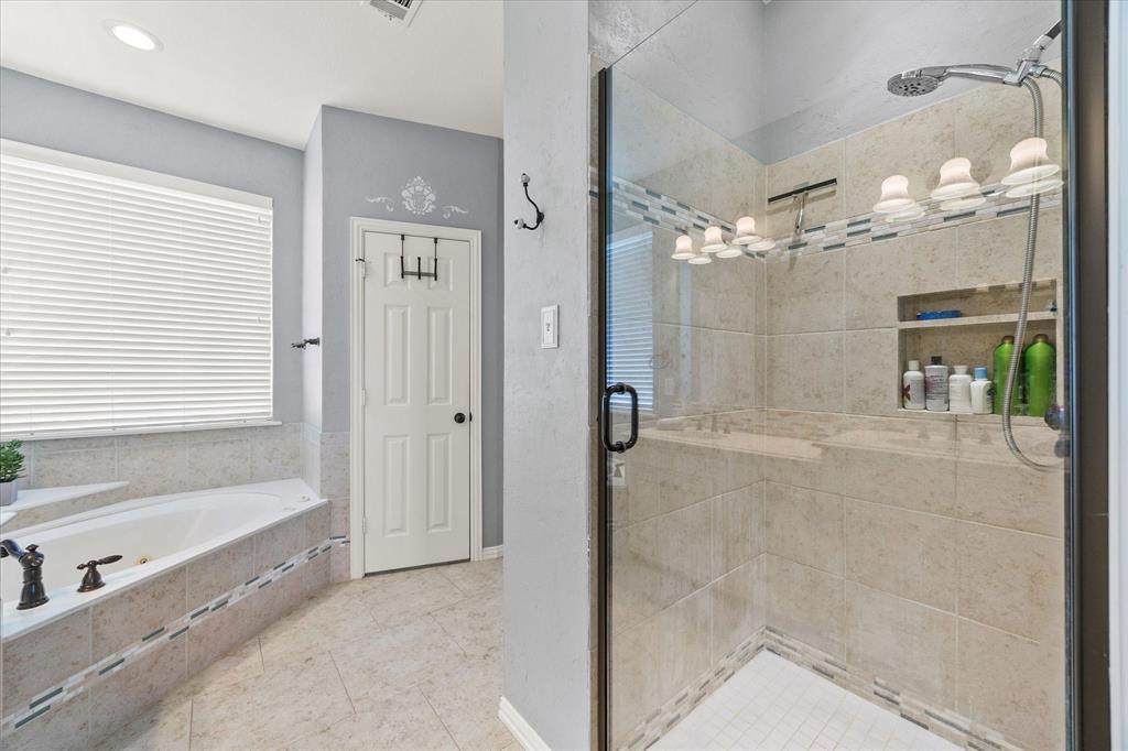 425 Chippendale Drive Heath, TX 75032 - Photo 19 of 37 a bathroom with a bathtub and a shower