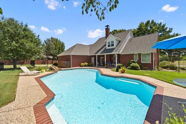 a view of a house with swimming pool and a yard