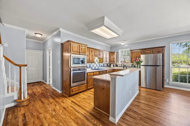 a kitchen with refrigerator cabinets and wooden floor