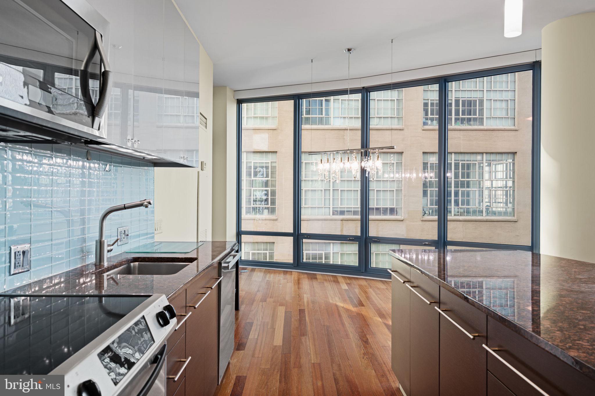 2101 Market Street, Unit 302 Philadelphia, PA 19103 - Photo 12 of 53 a kitchen with a large window a sink and cabinets