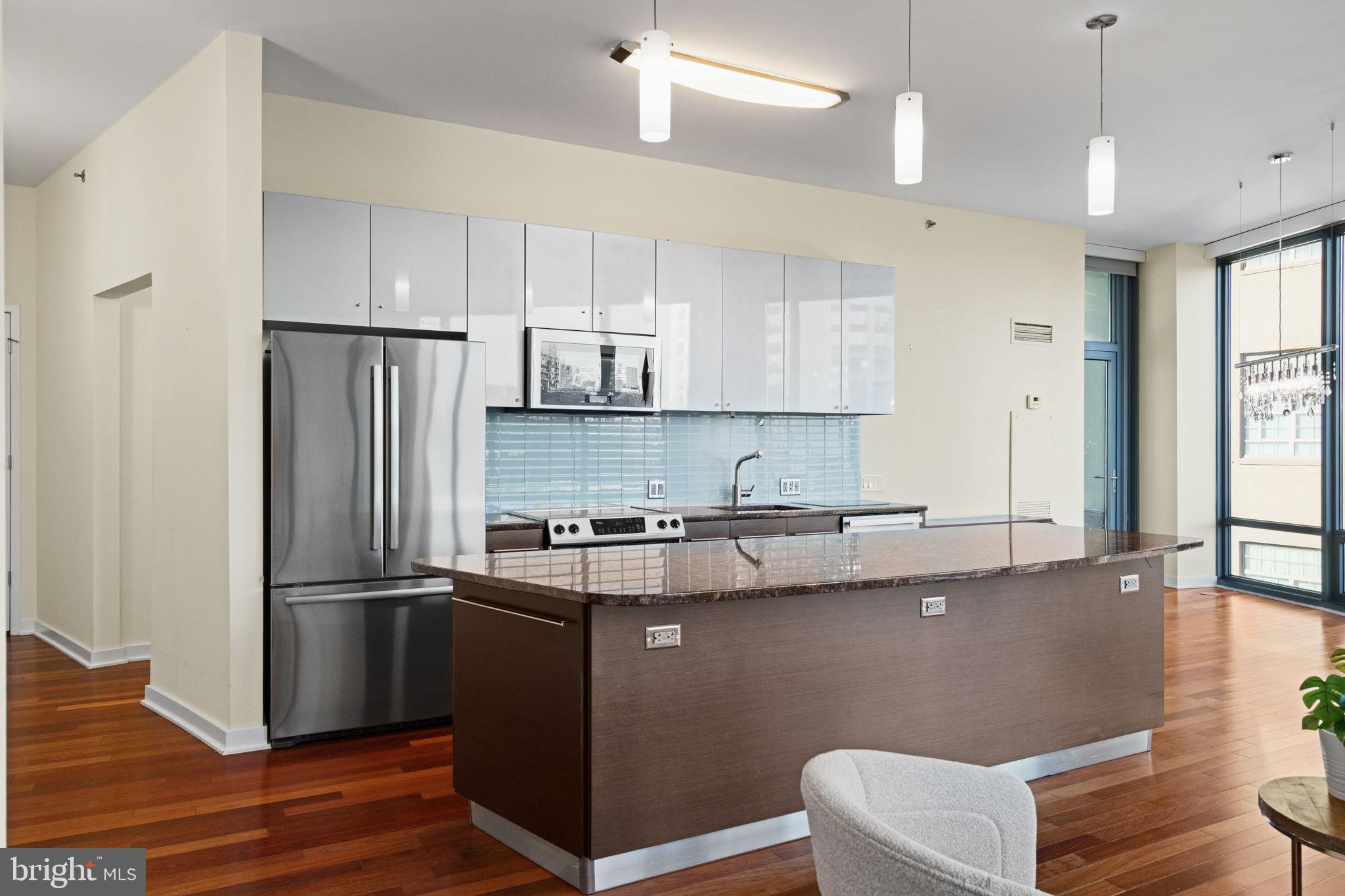 2101 Market Street, Unit 302 Philadelphia, PA 19103 - Photo 13 of 53 a kitchen with stainless steel appliances granite countertop a refrigerator a sink dishwasher a stove and white cabinets with wooden floor