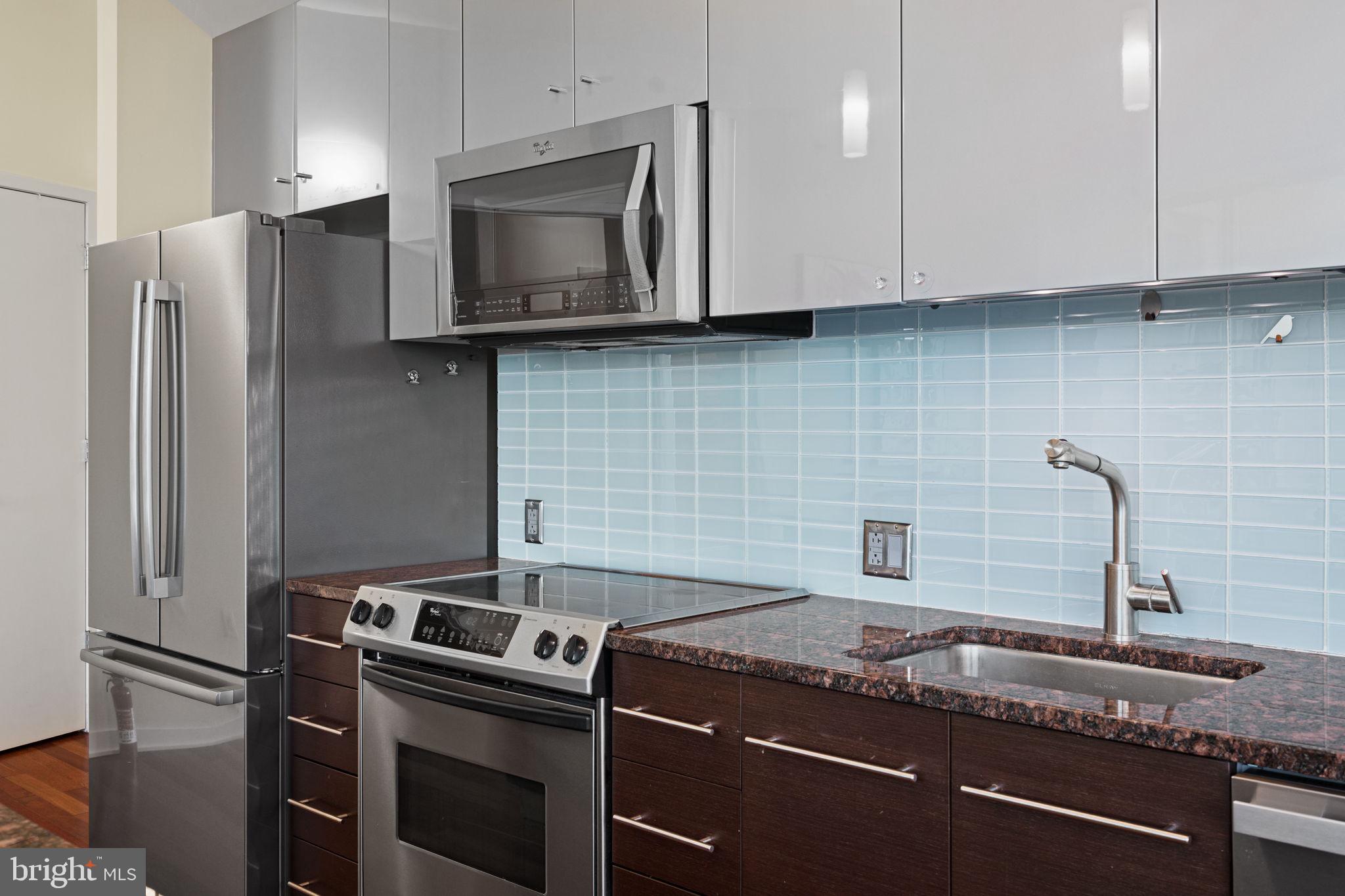 2101 Market Street, Unit 302 Philadelphia, PA 19103 - Photo 17 of 53 a kitchen with granite countertop a sink stove and refrigerator