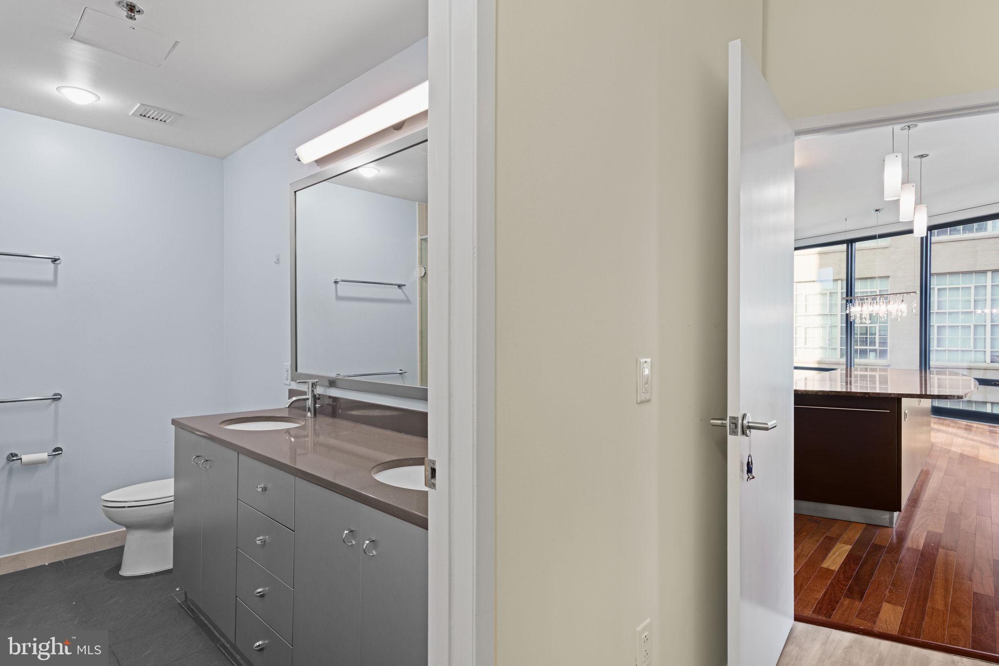 2101 Market Street, Unit 302 Philadelphia, PA 19103 - Photo 29 of 53 a bathroom with a granite countertop sink toilet and vanity