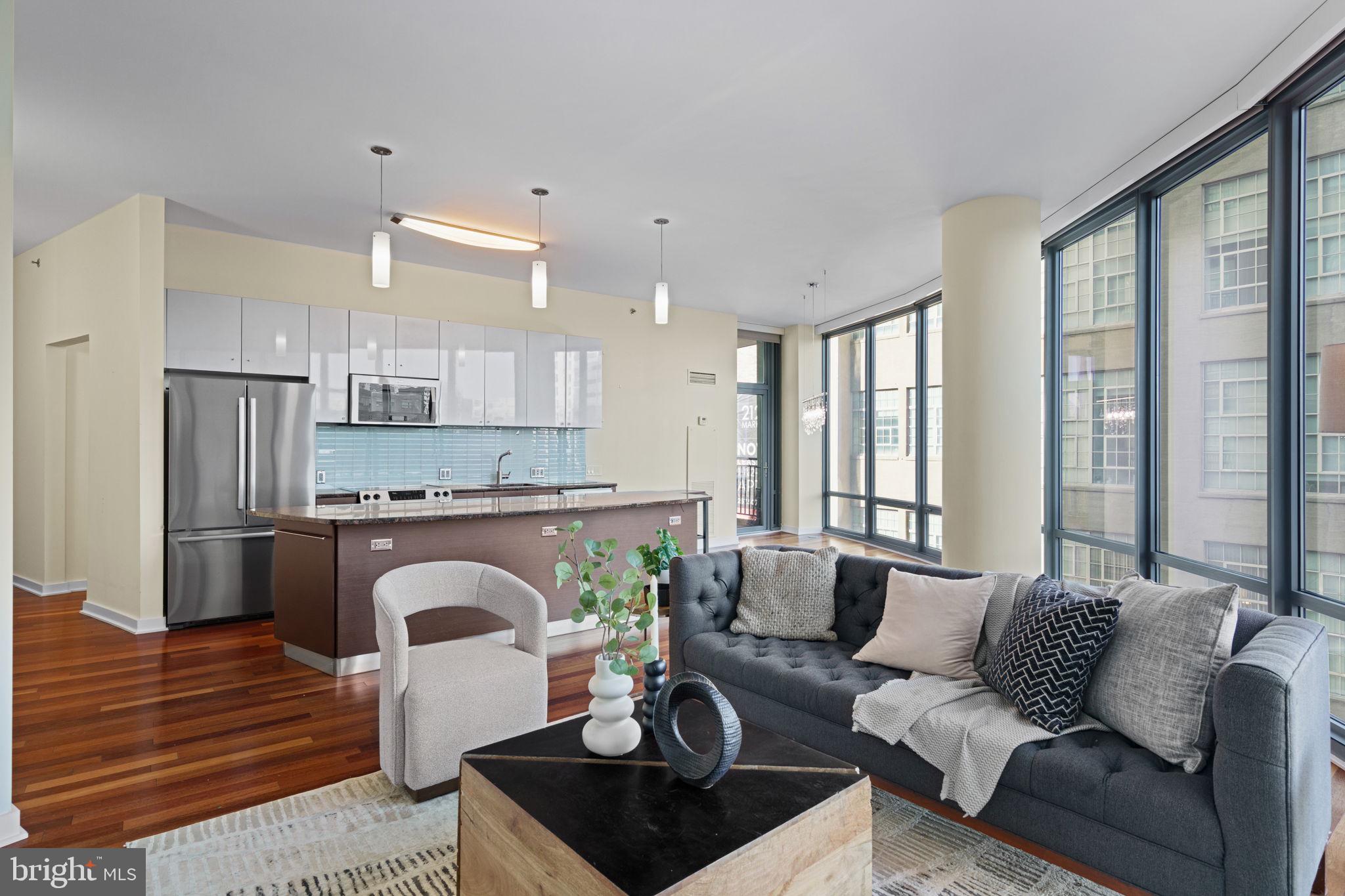 2101 Market Street, Unit 302 Philadelphia, PA 19103 - Photo 10 of 53 a living room with furniture a large window and a fireplace