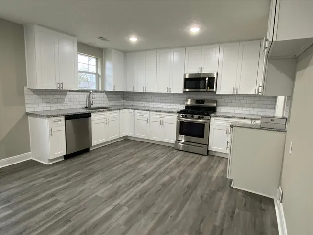 a kitchen with a sink a microwave and cabinets