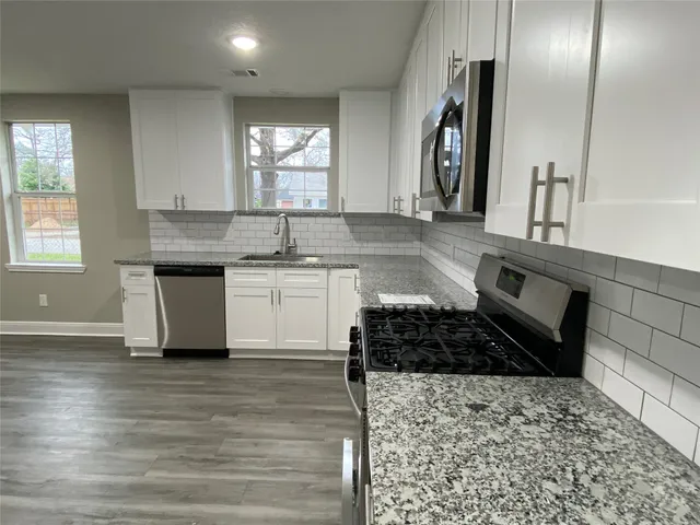 a kitchen with a sink and a stove top oven