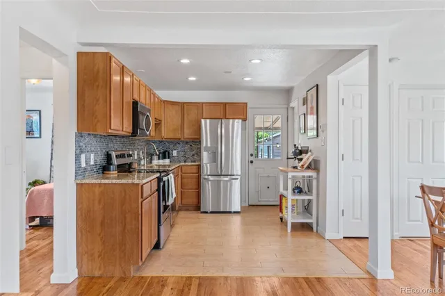 a kitchen with stainless steel appliances granite countertop a refrigerator and a stove top oven