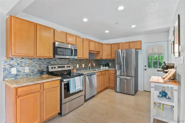 a kitchen with sink a microwave and refrigerator