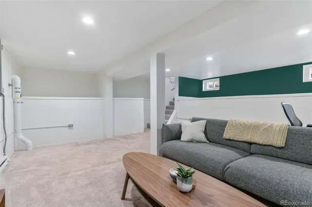 a living room with furniture and a air conditioner vent