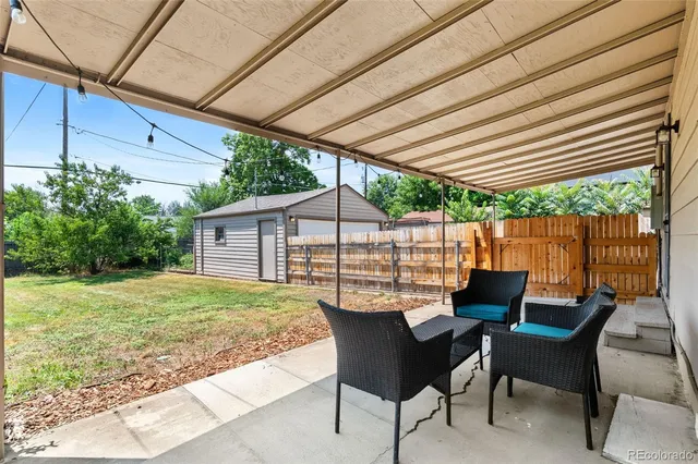 a patio with wooden table and chairs