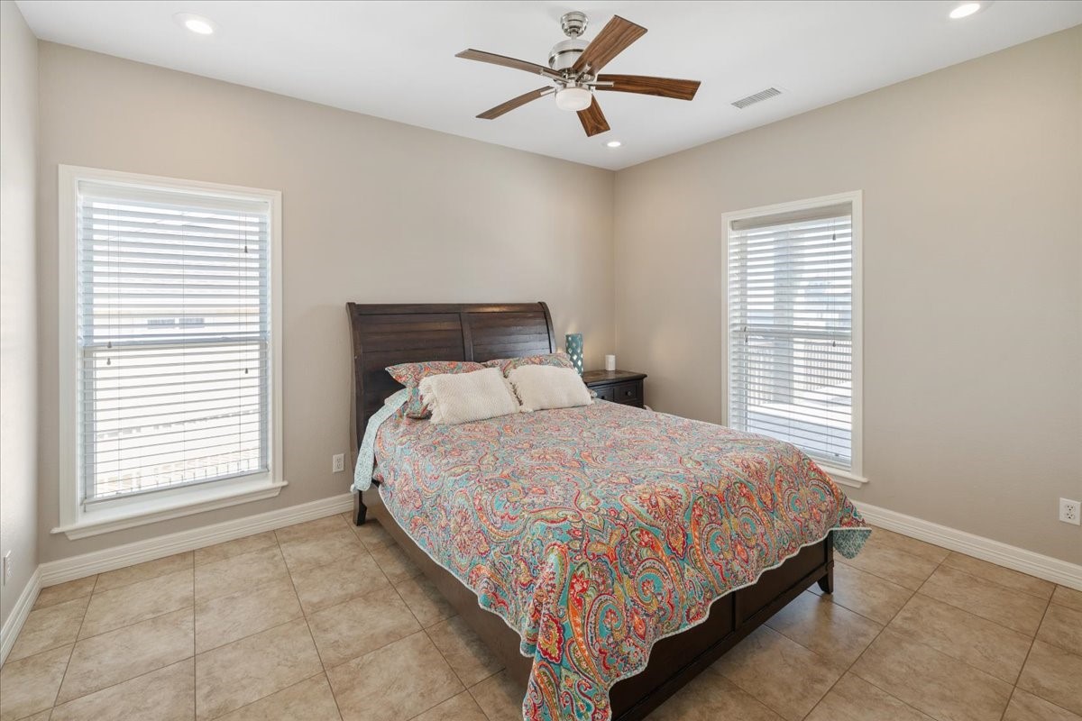 3093 Greg Street Crystal Beach, TX 77650 - Photo 30 of 48 a bedroom with a large bed and a ceiling fan