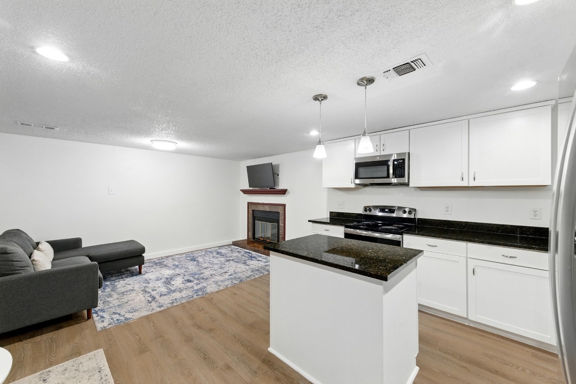 2401 Leon Street, Unit 306 Austin, TX 78705 - Photo 11 of 27 a kitchen with granite countertop a stove and a sink