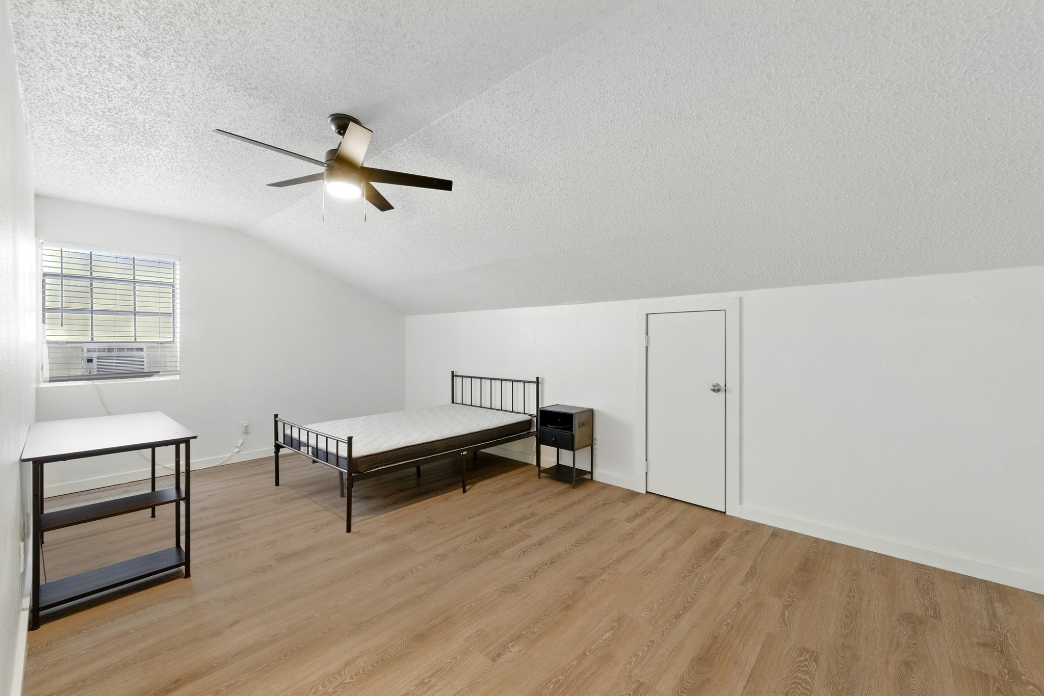 2401 Leon Street, Unit 306 Austin, TX 78705 - Photo 20 of 27 a view of a room with wooden floor and a ceiling fan