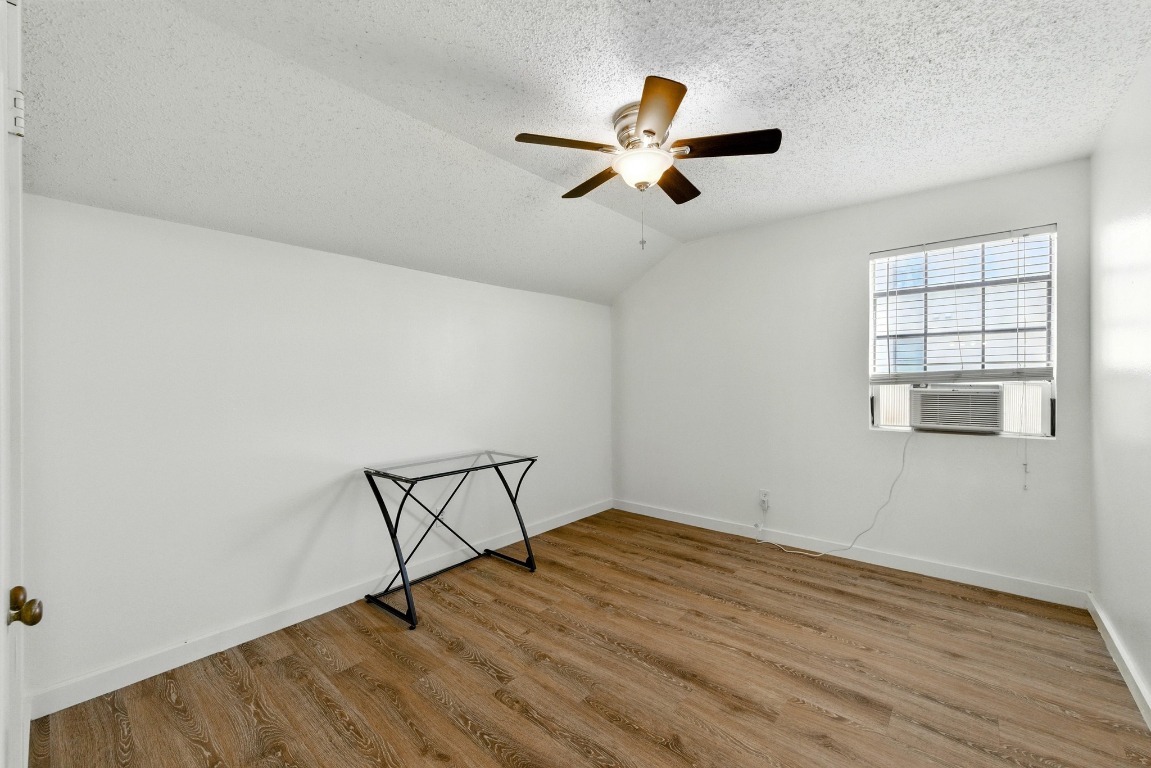 2401 Leon Street, Unit 306 Austin, TX 78705 - Photo 22 of 27 an empty room with wooden floor fan and windows