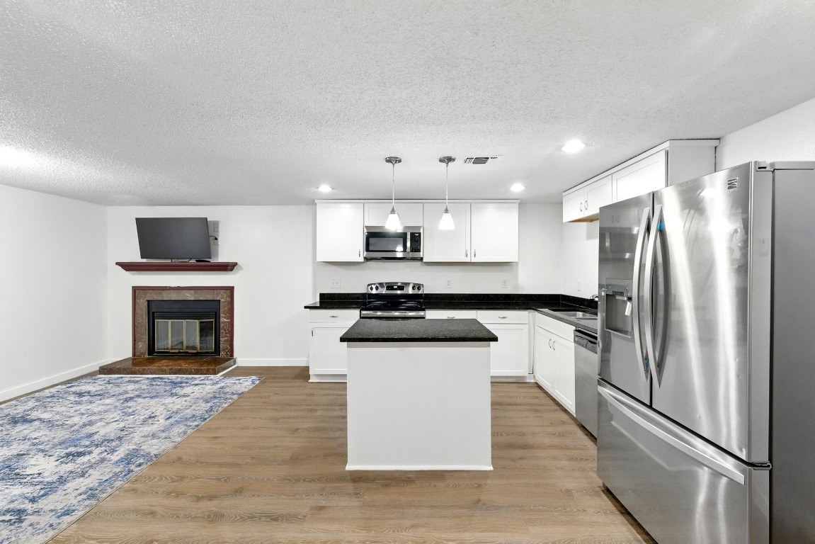 2401 Leon Street, Unit 306 Austin, TX 78705 - Photo 10 of 27 a kitchen with granite countertop a refrigerator stove and sink