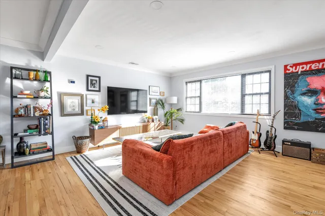 a living room with furniture a flat screen tv and a large window