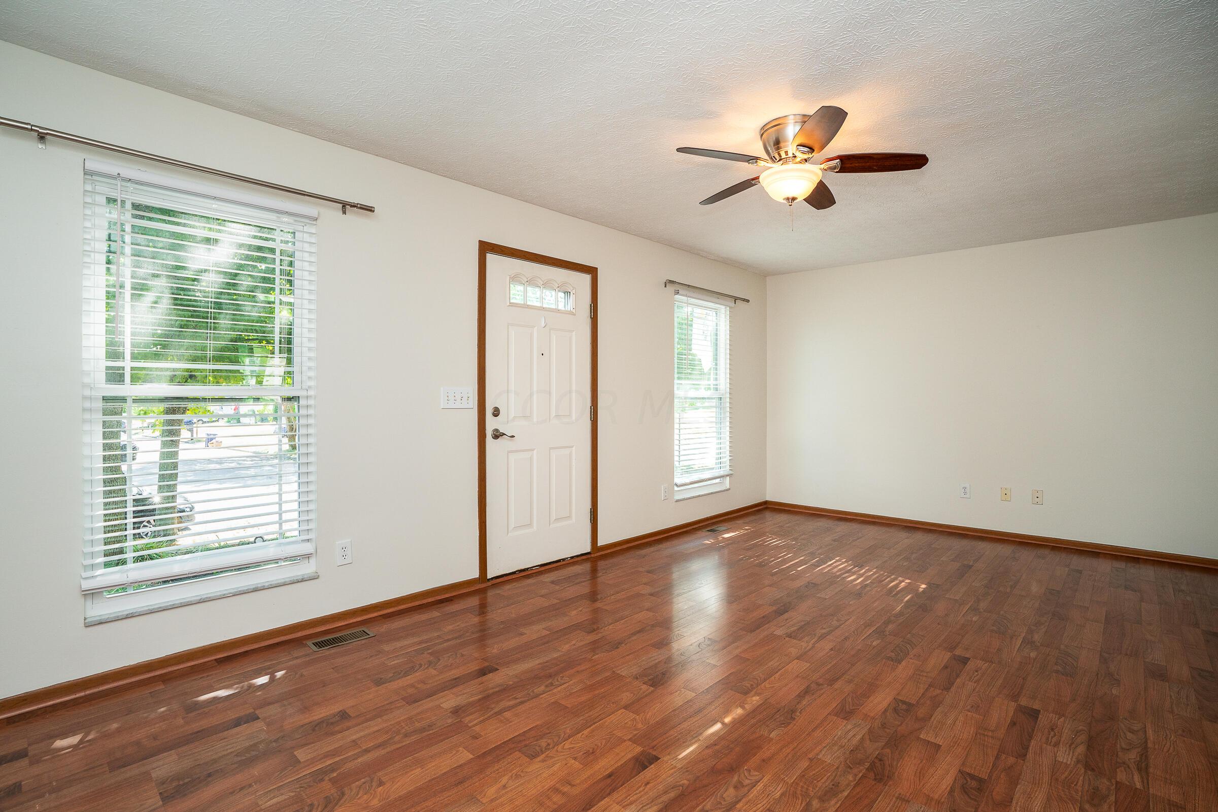 2135 Tonda Lane Grove City, OH 43123 - Photo 5 of 37 The large living room spans the width of the home and features 2 large updated windows and wood grain laminate flooring