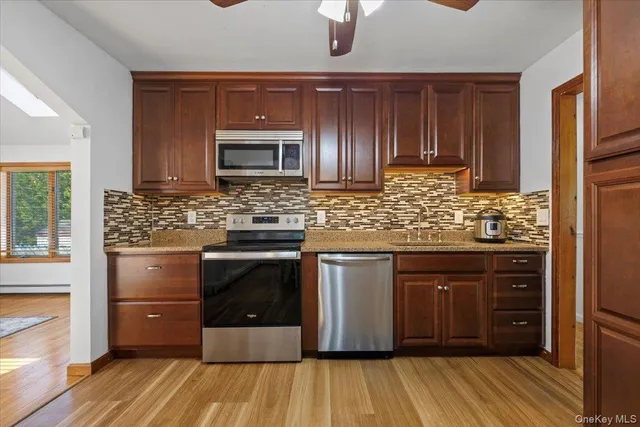 a kitchen with stainless steel appliances kitchen island granite countertop wooden cabinets and a sink