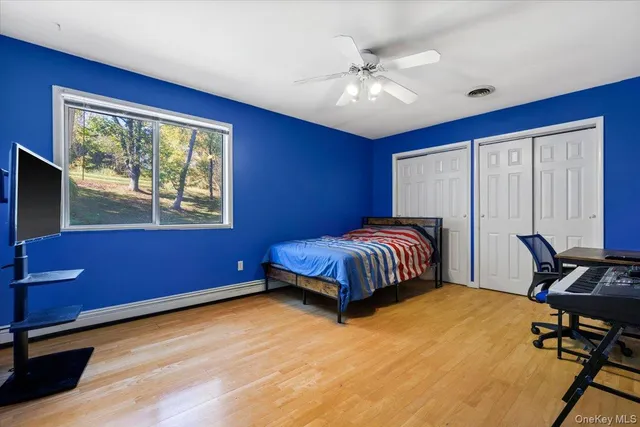 a bedroom with a bed and a dresser next to a window