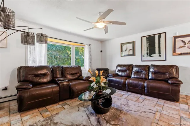 a living room with furniture ceiling fan and a window