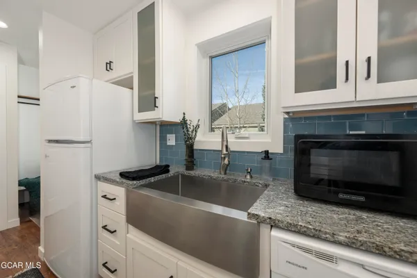 a kitchen with granite countertop a sink stainless steel appliances and cabinets