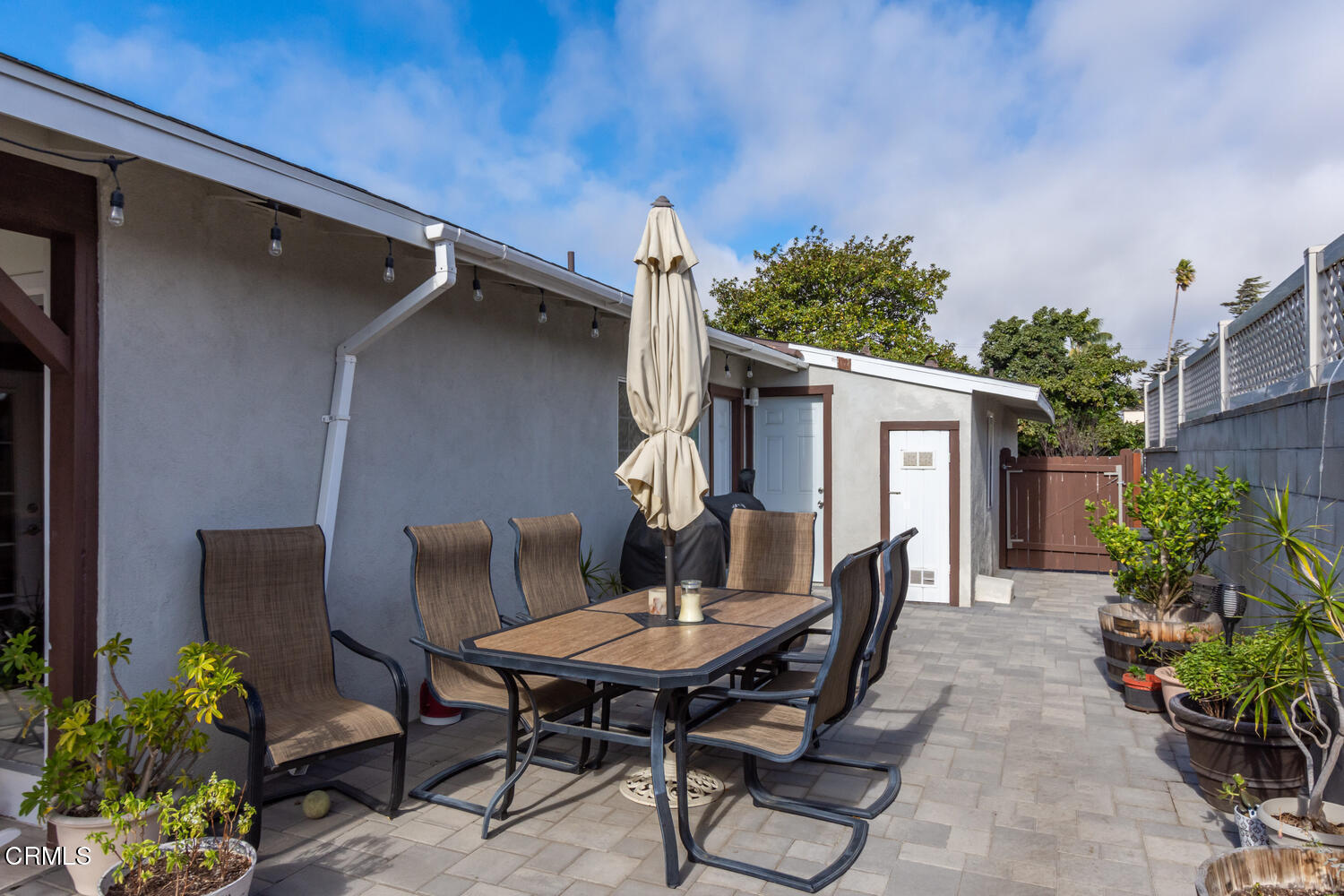 612 West Roderick Avenue Oxnard, CA 93030 - Photo 23 of 26 a view of a patio with table and chairs potted plants and floor to ceiling window