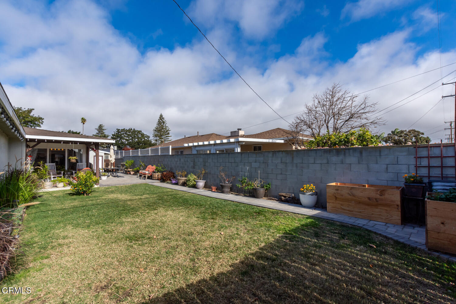 612 West Roderick Avenue Oxnard, CA 93030 - Photo 24 of 26 a view of a patio with table and chairs potted plants and wooden fence