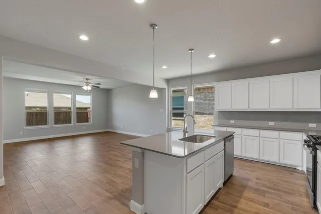 a kitchen with a sink cabinets and wooden floor