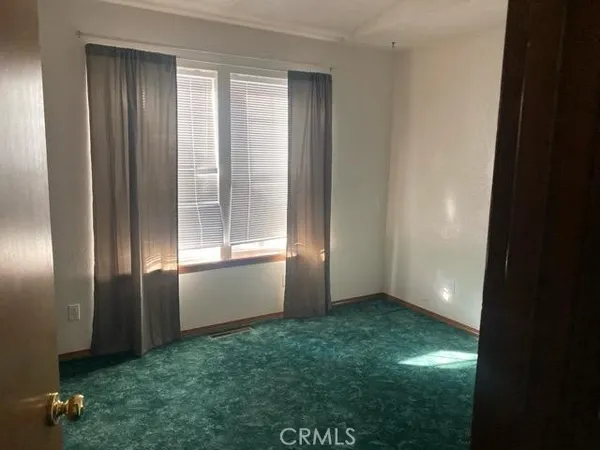 an empty room with closet and mirror