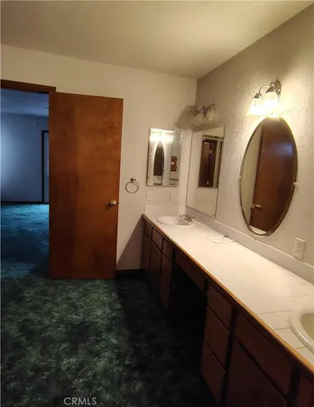 a bathroom with double vanity sinks and a mirror