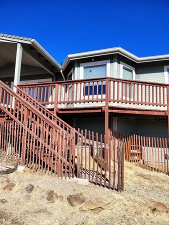 a view of a house with a small yard and wooden fence