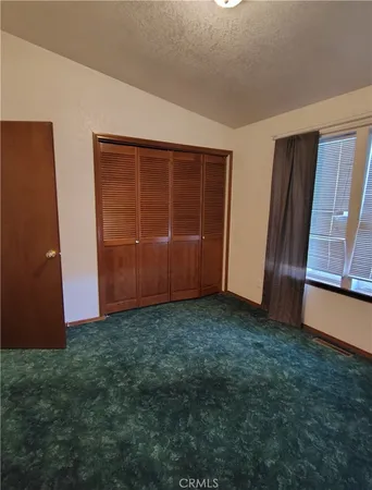a view of a room with wooden floor and a window