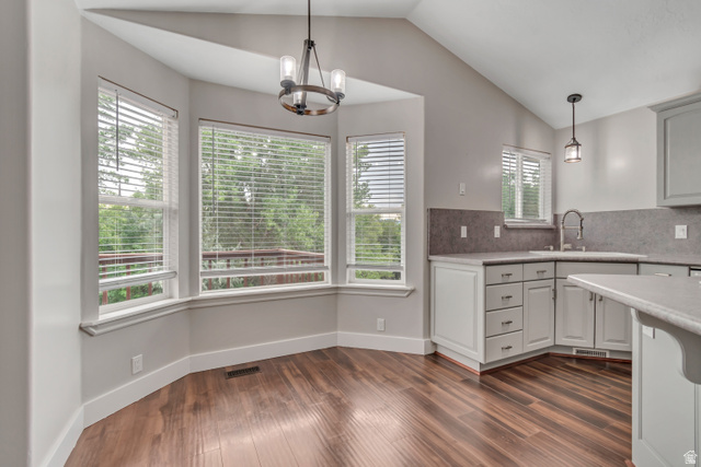 2154 Wasatch Boulevard Sandy, UT 84092 - Photo 24 of 55 Kitchen featuring decorative light fixtures, lofted ceiling, dark wood-style flooring, a chandelier, and decorative backsplash