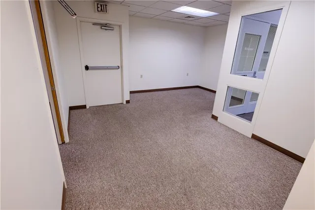 an empty room with a fireplace and mirror