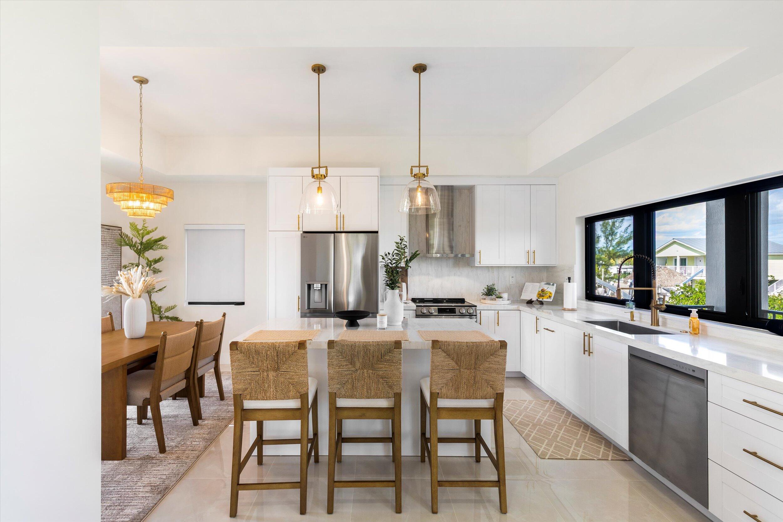 27433 Antigua Road Summerland Key, FL 33042 - Photo 20 of 64 a open kitchen with stainless steel appliances granite countertop a stove a sink a kitchen island with chairs and white cabinets