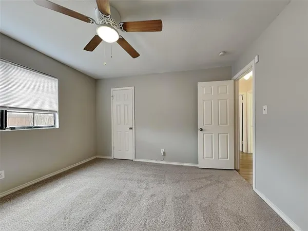 an empty room with chandelier fan