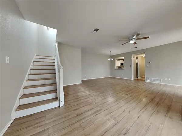 a view of a livingroom with wooden floor and stairs