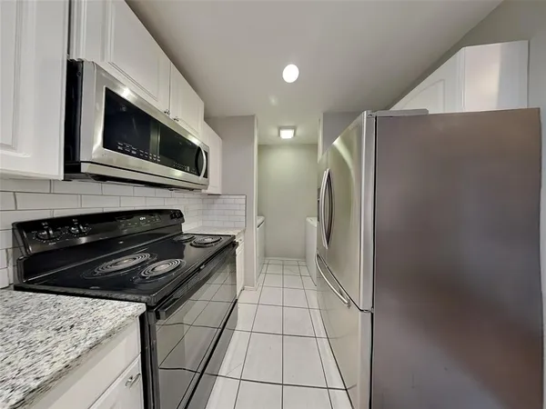 a kitchen with granite countertop a stove and a microwave