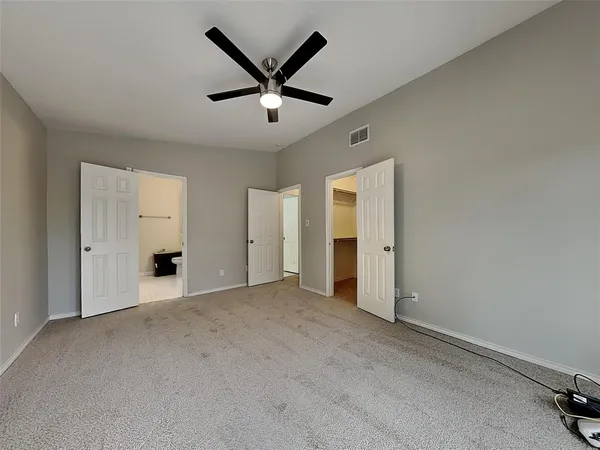 an empty room with closet and windows