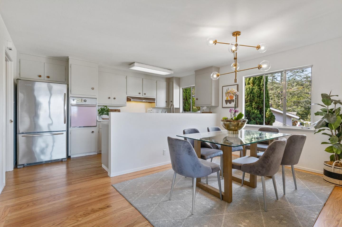 2203 Ewell Road Belmont, CA 94002 - Photo 16 of 50 a kitchen with stainless steel appliances a dining table chairs refrigerator and sink