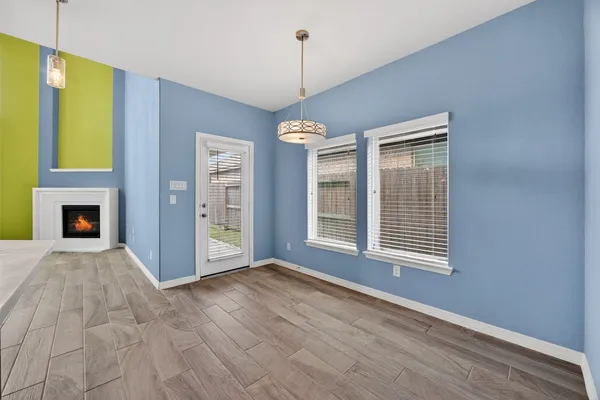 a view of an empty room with a window and fireplace