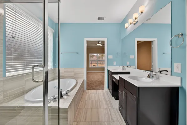 a en suite bathroom with a granite countertop sink and a mirror