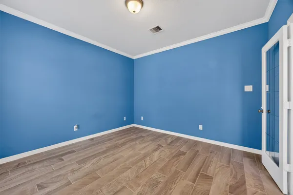 a view of empty room with wooden floor