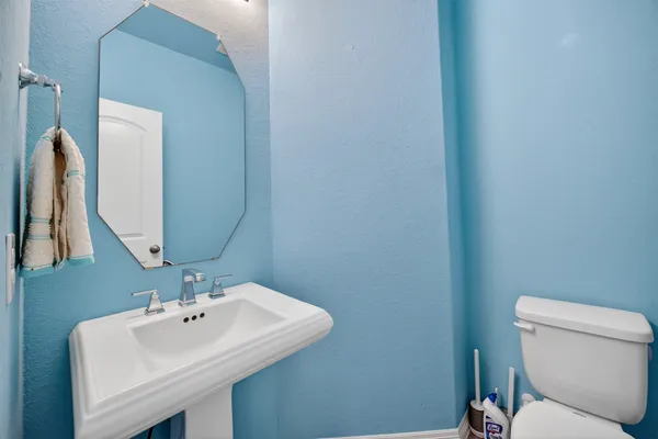 a bathroom with a sink a toilet and mirror
